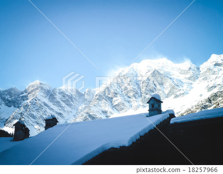 Snow-covered roof on a background of mountains 18257966