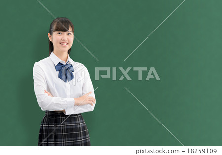 Girls high school student who is standing in front of the blackboard in the school's classroom Girls high school student who is standing in front of the blackboard in the school's classroom 18259109