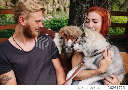 beautiful couple together with dog on a swing 18261723