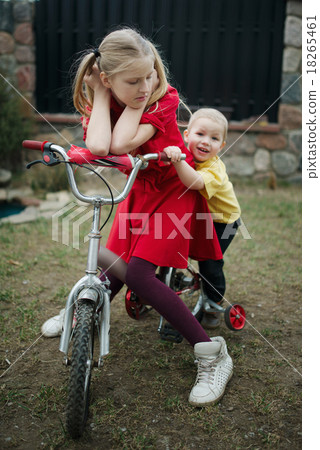 children ride on bicycle in yard children ride on bicycle in yard 18265461