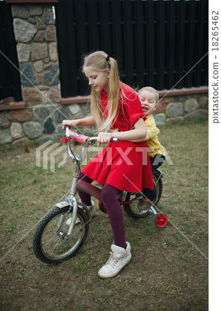 children ride on bicycle in yard children ride on bicycle in yard 18265462