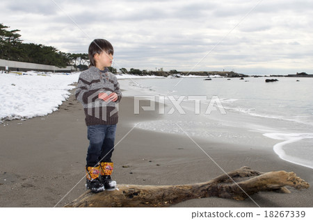 Children standing on the coast where the snow remains and coastal scenery where the snow remains 18267339