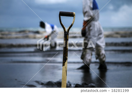Workers remove crude oil from a beach 18281199