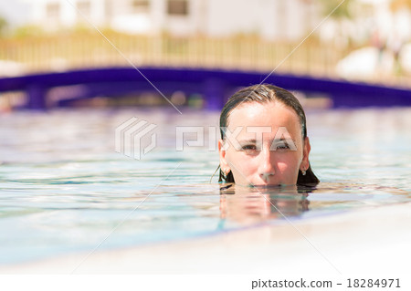 Young caucasian woman enjoying swimming in pool Young caucasian woman enjoying swimming in pool 18284971