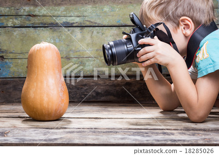 Funny boy trying to take photo of ripe pumpkin Funny boy trying to take photo of ripe pumpkin 18285026