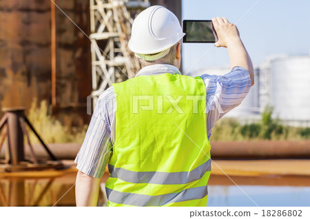 Engineer with tablet PC near to the tanks Engineer with tablet PC near to the tanks 18286802