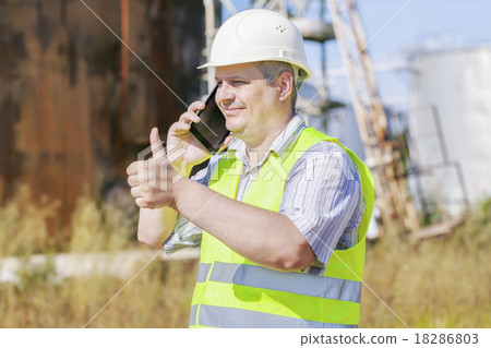 Engineer showing thumb up near to the tanks Engineer showing thumb up near to the tanks 18286803