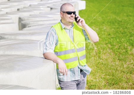 Farmer talking on smartphone near bales Farmer talking on smartphone near bales 18286808