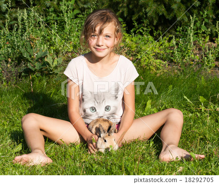 Girl with rabbit sitting on the meadow Girl with rabbit sitting on the meadow 18292705