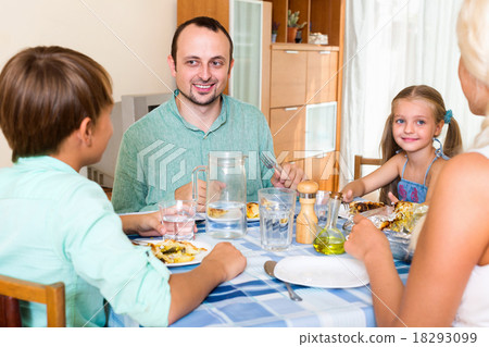Smiling family with two kids dining 18293099