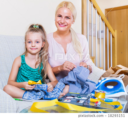 Mother teaching daughter to sew 18293151