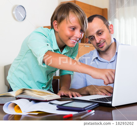 Father helping teenage son with homework. Father helping teenage son with homework. 18293202