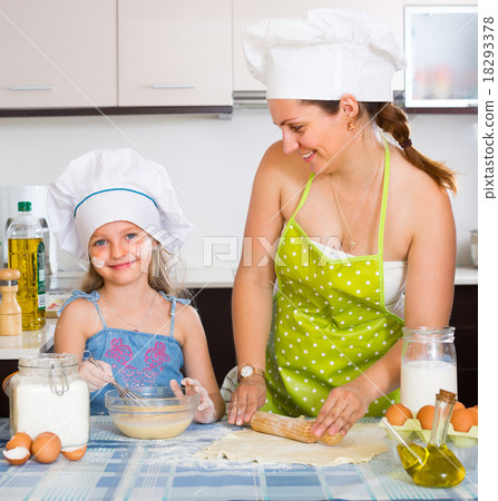 Girl helping mother to make a dough. Girl helping mother to make a dough. 18293378