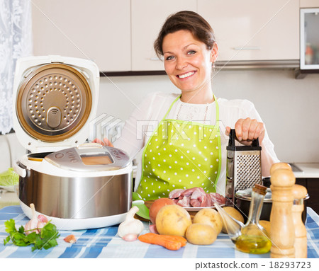 Happy woman using slo-cooker 18293723