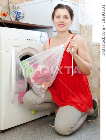 woman in red with laundry bag in kitchen 18293831