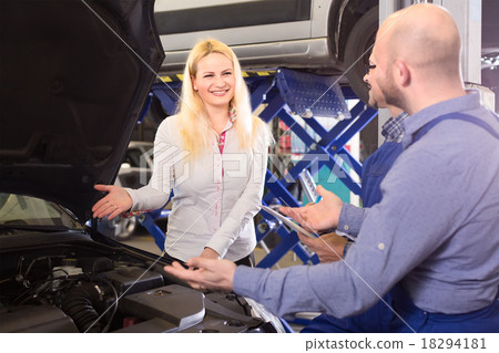 Happy woman at a car repair shop Happy woman at a car repair shop 18294181