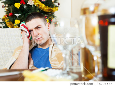 Young sick man with hangover and towel by head Young sick man with hangover and towel by head 18294372