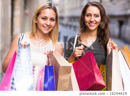 Two young women holding shopping bags. 18294629