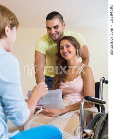 Happy couple with disabled wife talking with social worker Happy couple with disabled wife talking with social worker 18294695