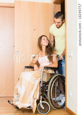 Man and his wife in wheelchair at the door Man and his wife in wheelchair at the door 18294757