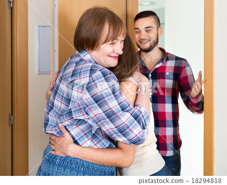 Happy mother greeting young couple 18294818