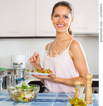Young woman eating salad with vegetables Young woman eating salad with vegetables 18294843