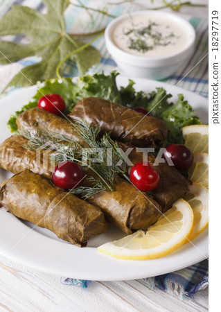 Stuffed grape leaves on a plate and sauce vertical Stuffed grape leaves on a plate and sauce vertical 18297719