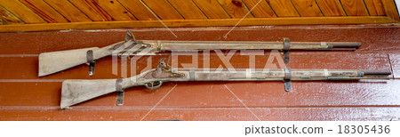 Old pump action shotguns on wooden wall 18305436