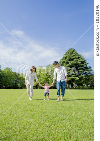 Three families walking hand in hand across the park 18320146