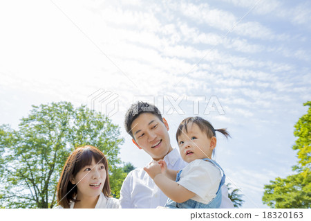 Three-person family playing in the park Three-person family playing in the park 18320163
