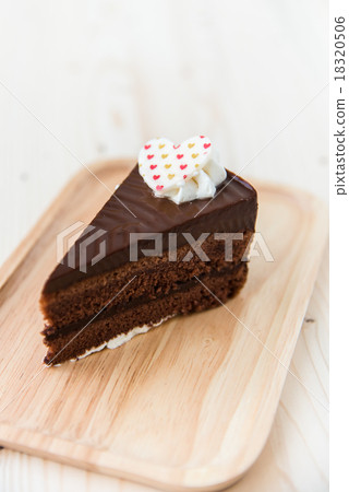 Chocolate cake slice on wooden plate. Chocolate cake slice on wooden plate. 18320506