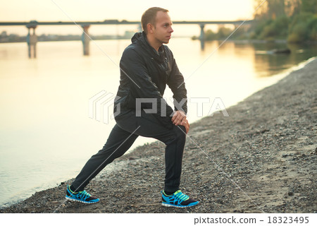 Athletic man doing exercise on the beach at sunset Athletic man doing exercise on the beach at sunset 18323495