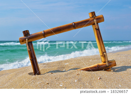 Seascape with bamboo frame on the beach sand Seascape with bamboo frame on the beach sand 18326657