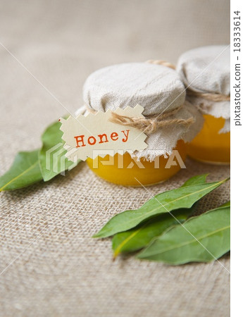A glass of honey and bay leaves A glass of honey and bay leaves 18333614