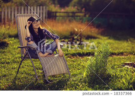 girl in a wide hat resting on a sun lounger on the ranch girl in a wide hat resting on a sun lounger on the ranch 18337366