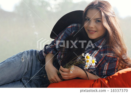 Happy American woman in a cowboy hat field wild flowers Happy American woman in a cowboy hat field wild flowers 18337370