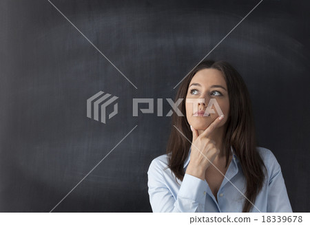 Thoughtful young woman on chalkboard background Thoughtful young woman on chalkboard background 18339678