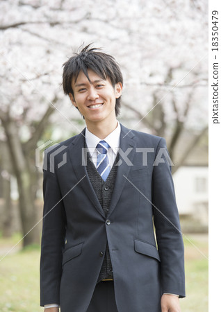 A man from a new hiring standing in front of cherry blossoms A man from a new hiring standing in front of cherry blossoms 18350479