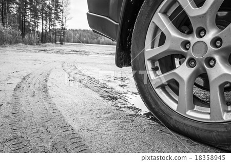 Car wheel with light alloy disc on dirty road Car wheel with light alloy disc on dirty road 18358945