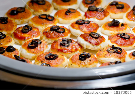 round meat pies with topping black olive sliced  18373095