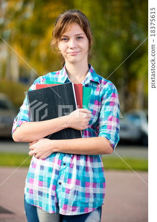 Portrait of young alluring woman holding education Portrait of young alluring woman holding education 18375615
