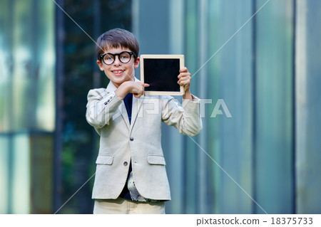 Cute little boy holding empty blackboard 18375733