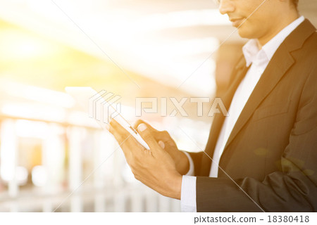Businessman using tablet computer at train station 18380418