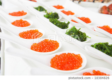 red caviar close-up in white spoons on banquet 18384826