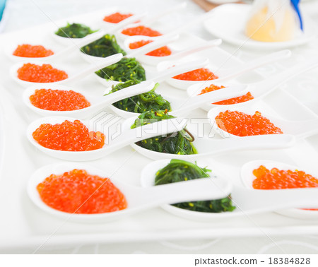 red caviar close-up in white spoons on banquet 18384828