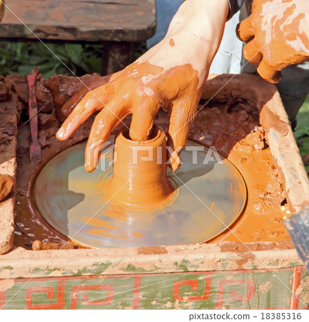 Potter makes on pottery wheel clay pot. 18385316