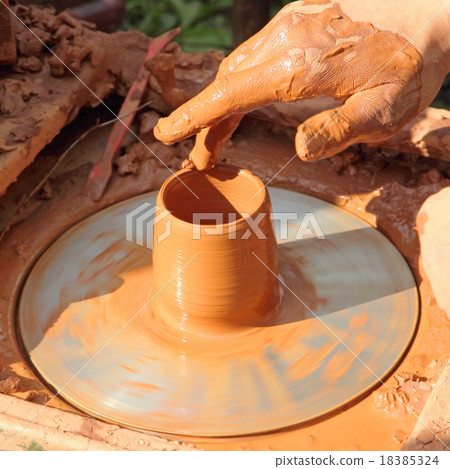 Potter hand taken closeup on pottery wheel. 18385324