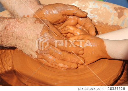 Potter and little pupil hands on wheel pottery  18385326