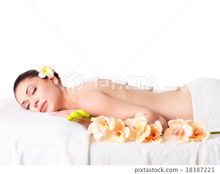 woman relaxing in spa salon with hot stones woman relaxing in spa salon with hot stones 18387221
