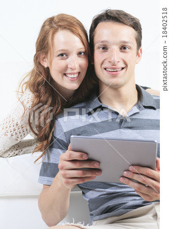 beautiful Couple on sofa with digital tablet 18402518